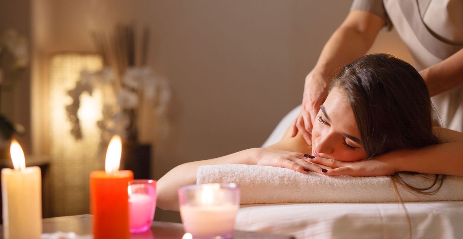 A woman receiving a treatment from a masseuse